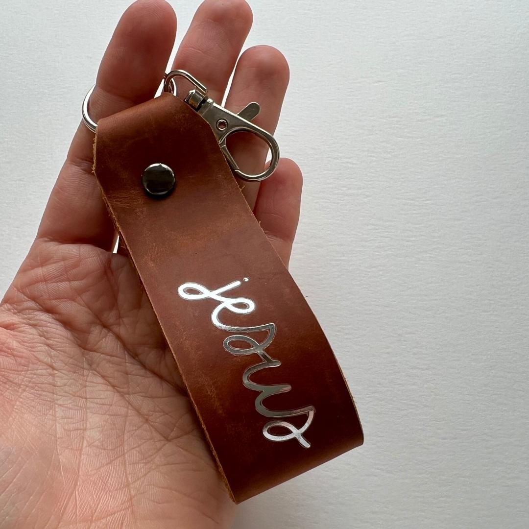 christlicher Schlüsselanhänger aus braunem Leder mit Silberschrift "jesus"