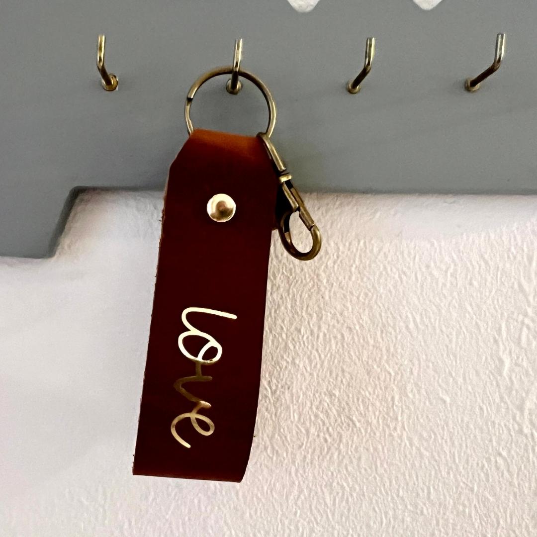 christlicher Schlüsselanhänger aus braunem Leder mit Goldschrift "love"