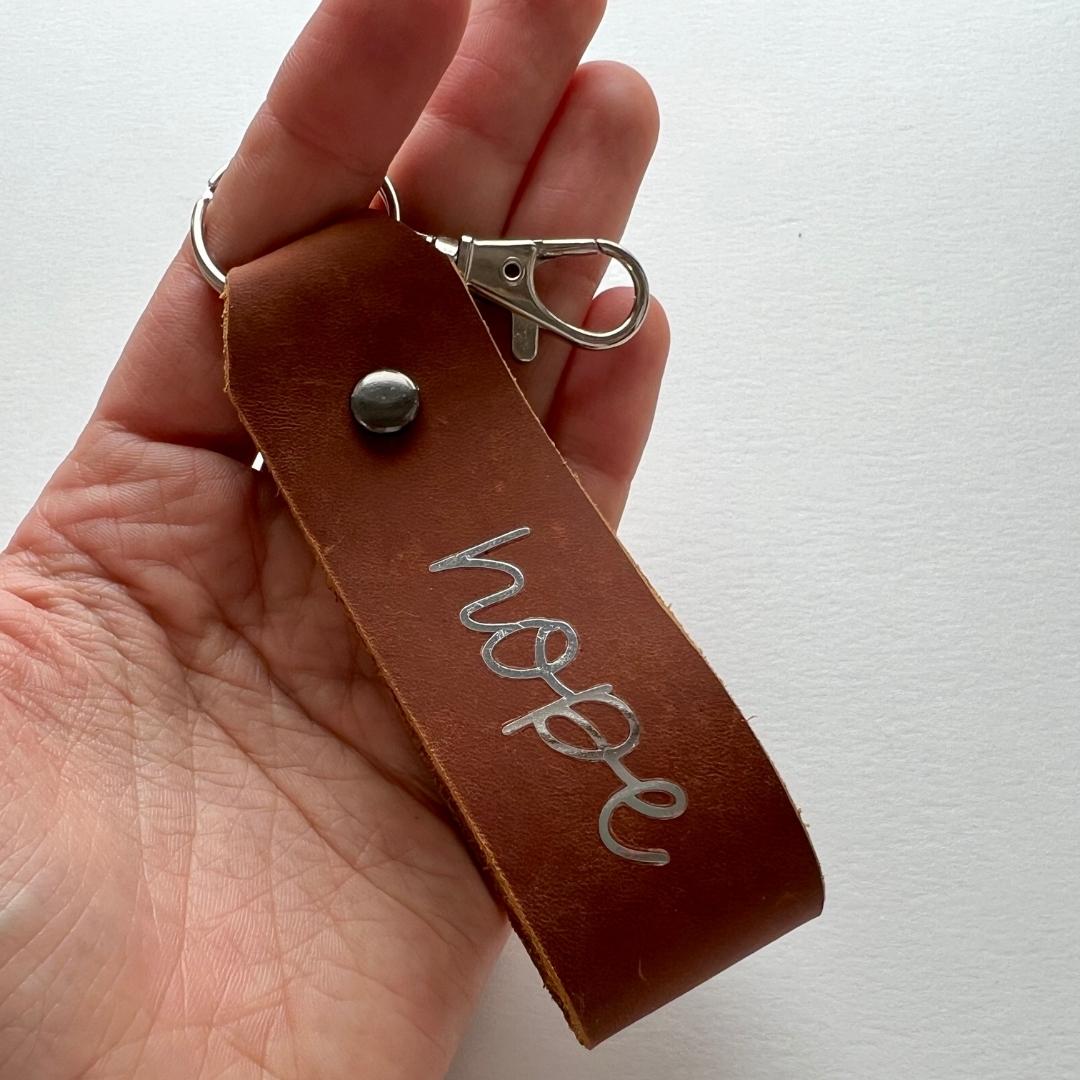 christlicher Schlüsselanhänger als braunem Leder mit Goldschrift "hope"